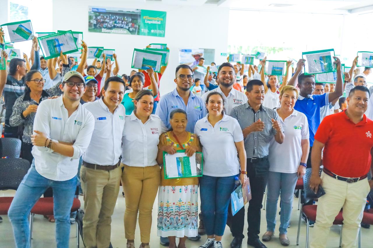Grupo de personas mostrando sus títulos, durante el evento de entrega de títulos en Puerto Asís, Putumayo.
