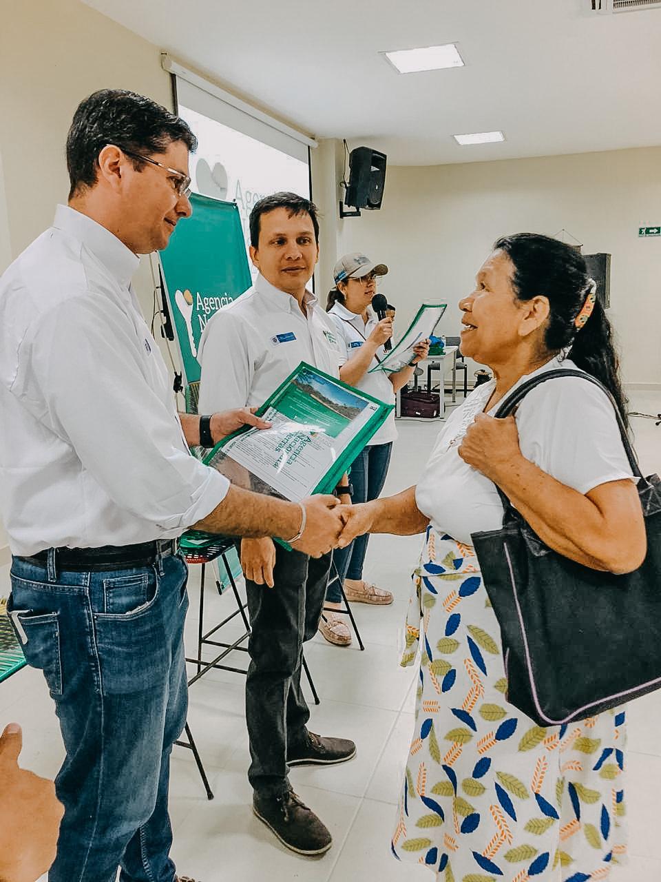 Un funcionario de la ANT entrega el título de propiedad a las manos de una mujer campesina en Puerto Libertador – Córdoba.