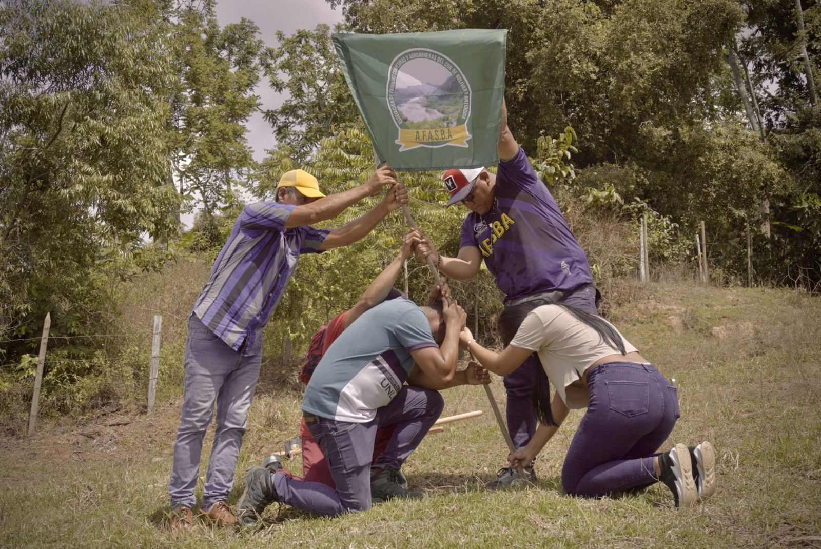 Campesinos sembrando simbolicamente una bandera de una asociación.