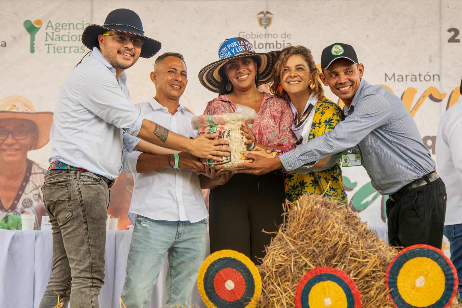 Campesinos durante el acto de entrega junto a la Ministra de Agricultura y el Director de la ANT.