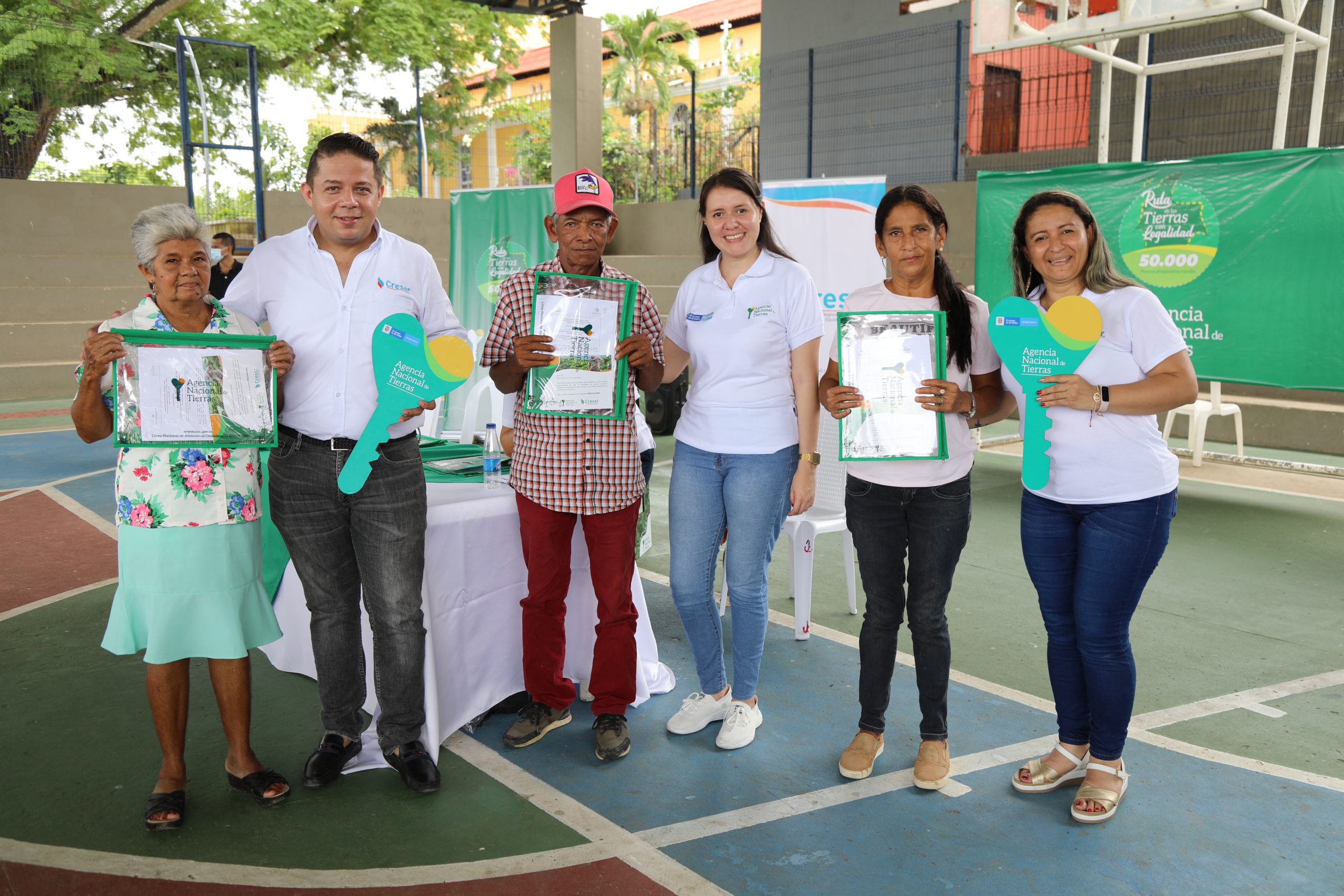 Campesinos de sucre mostrando título que recibieron junto a los funcionarios de la ANT