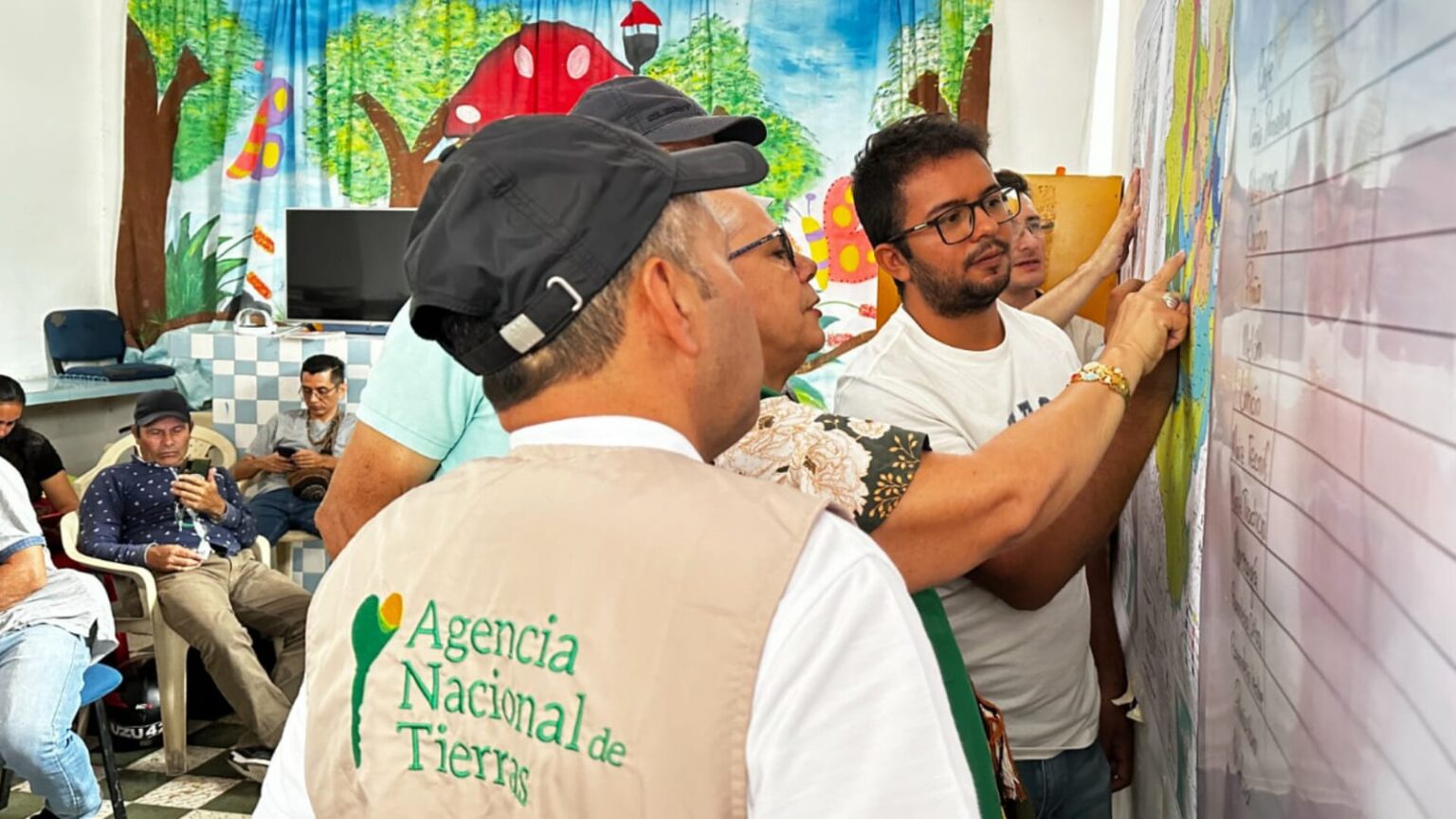 Funcionarios de la Agencia Nacional de Tierras y funcionarios de alcaldías municipales de Paicol y El Agrado en el Huila revisando el mapa.