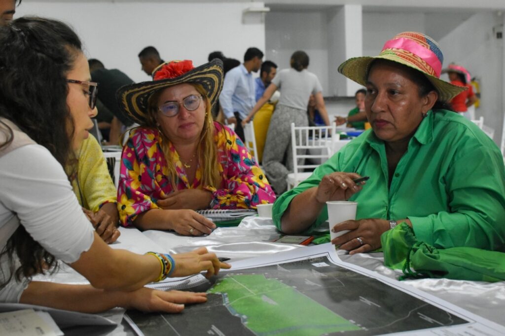 Tres mujeres conversando en una mesa de diálogo.
