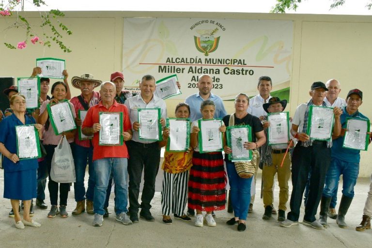 Beneficiados sosteniendo sus títulos en la alcaldía municipal del municipio de Ataco.