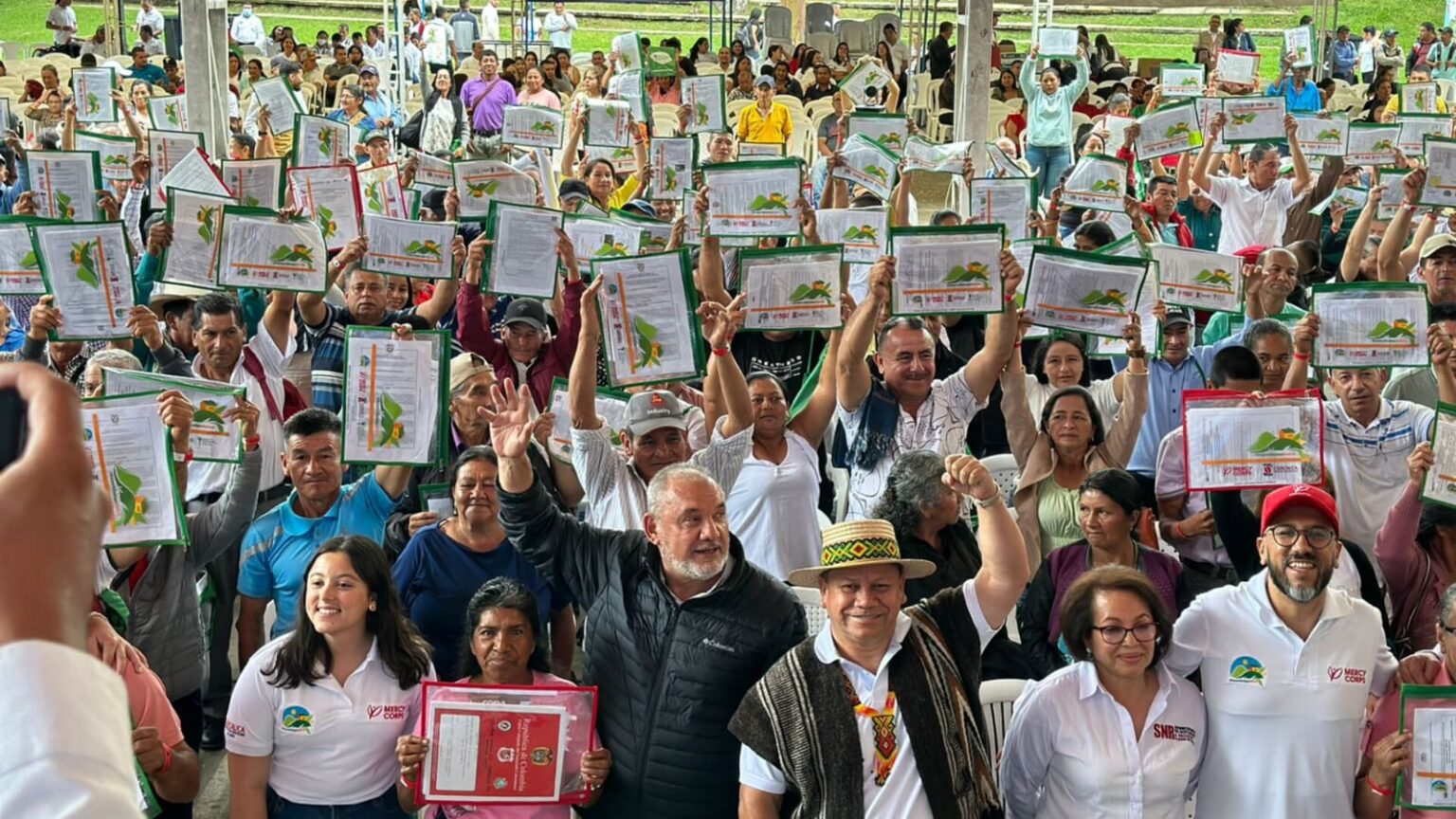Familias campesinas sosteniendo sus títulos y miembros de la ANT en Cauca.