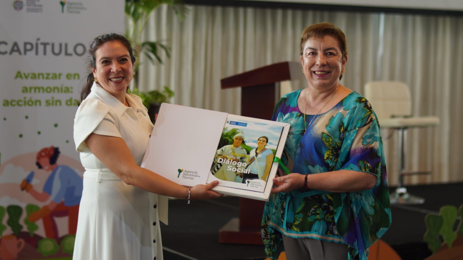 Ex directora de la ANT junto a otra funcionaria, mostrando el libro Memorias para el Diálogo Social