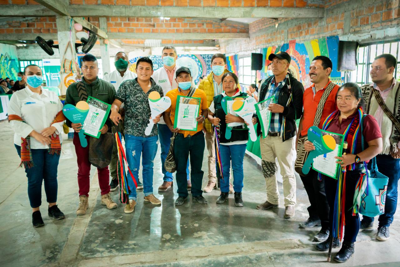Funcionarios de la ANt junto a personas de diferentes resguardos indigenas mostrando los titulos de ampliación y constitución