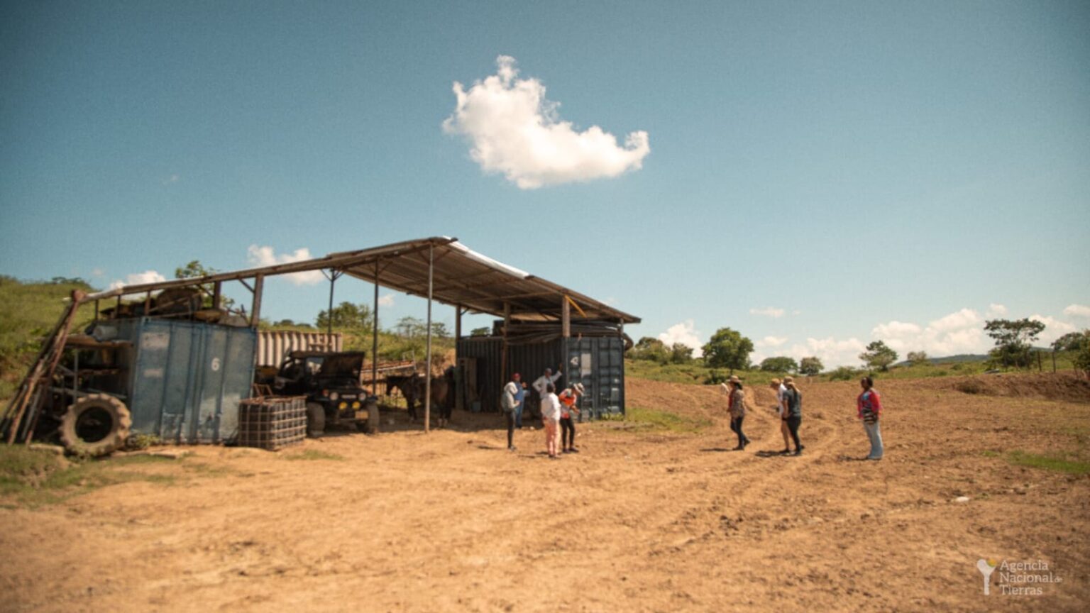 Fotografía de un terreno y algunos campesinos en él.