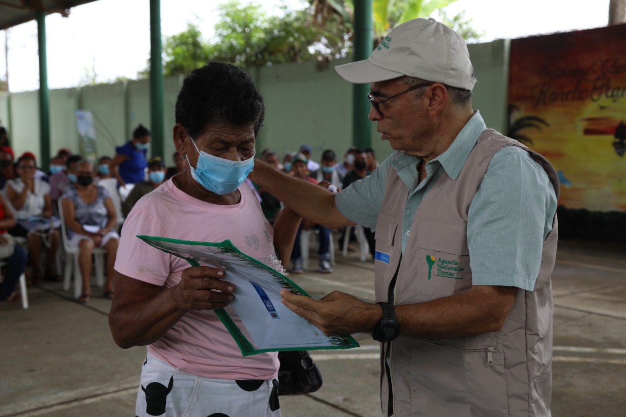 Campesina de monteria recibiendo título de propiedad por parte de funcionario 