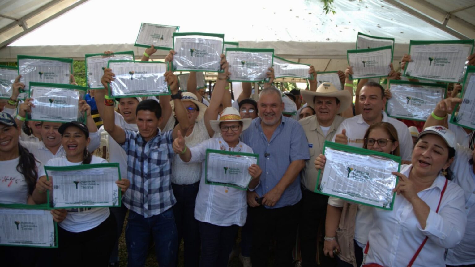 Campesinos celebrando con sosteniendo sus títulos, entre ellos, Gerardo Vega.