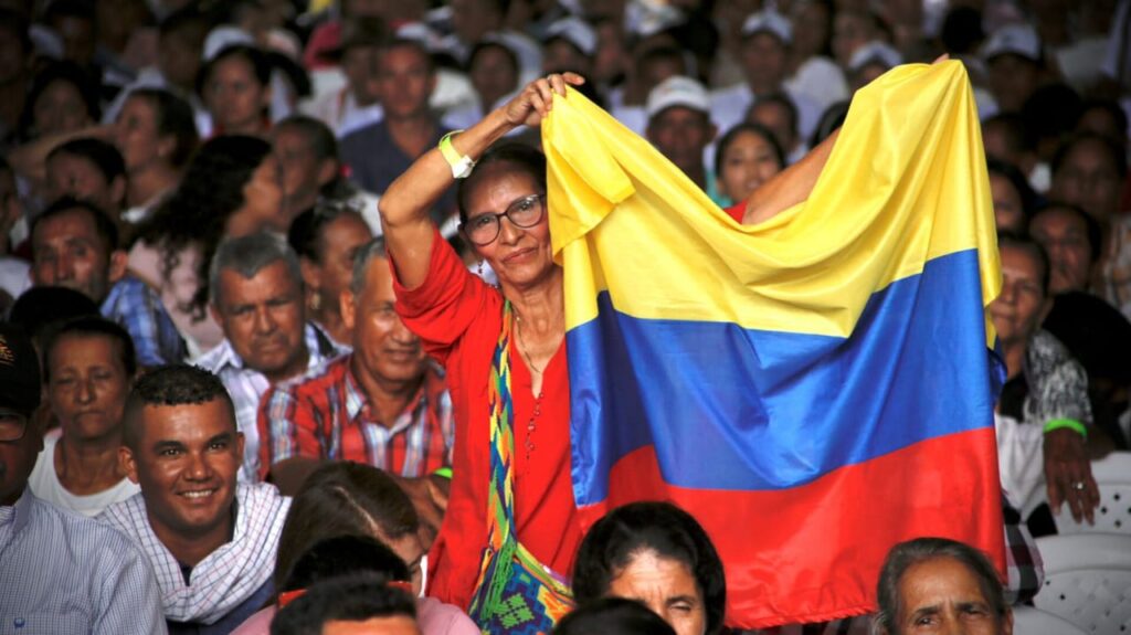 Mujer sosteniendo una bandera de Colombia en medio de la asamblea popular en Aguachica, Cesar.
