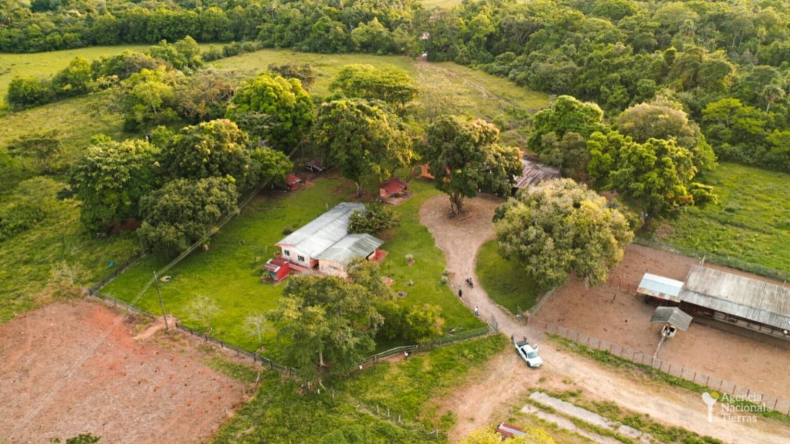 Fotografía aérea de un terreno con árboles y algunas casas.
