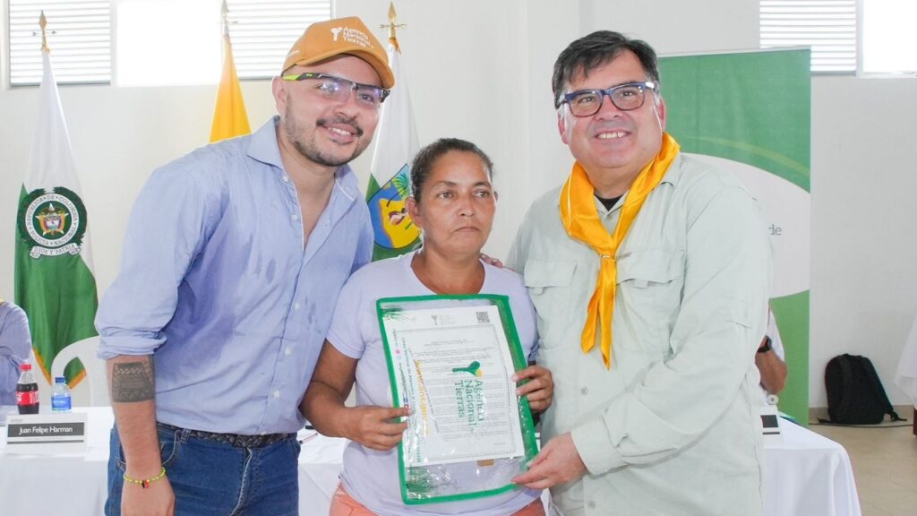 Mujer recibiendo el título de su predio.