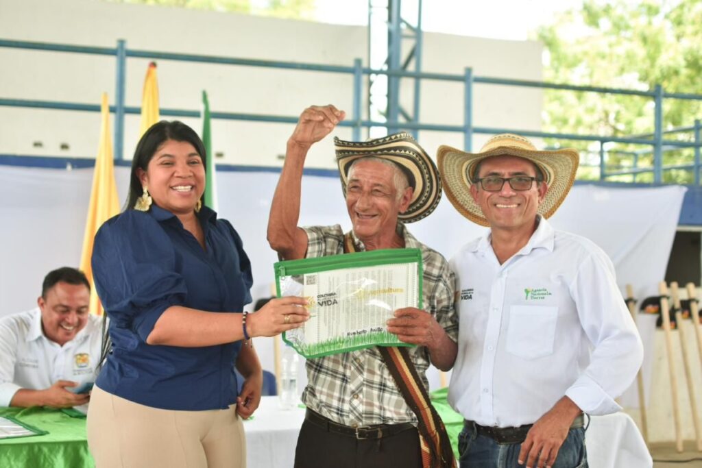Campesino recibiendo su titulo de tierra por parte de funcionarios de la ant