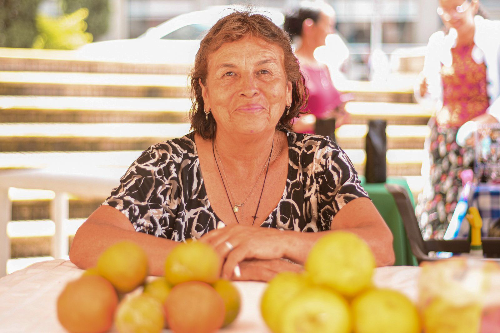 mujer-apoyandose-sobre-mesa-de-naranjas