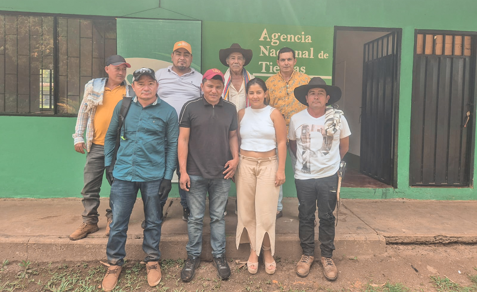 un-grupo-de-personas-parados-frente-a-un-edificio-verde