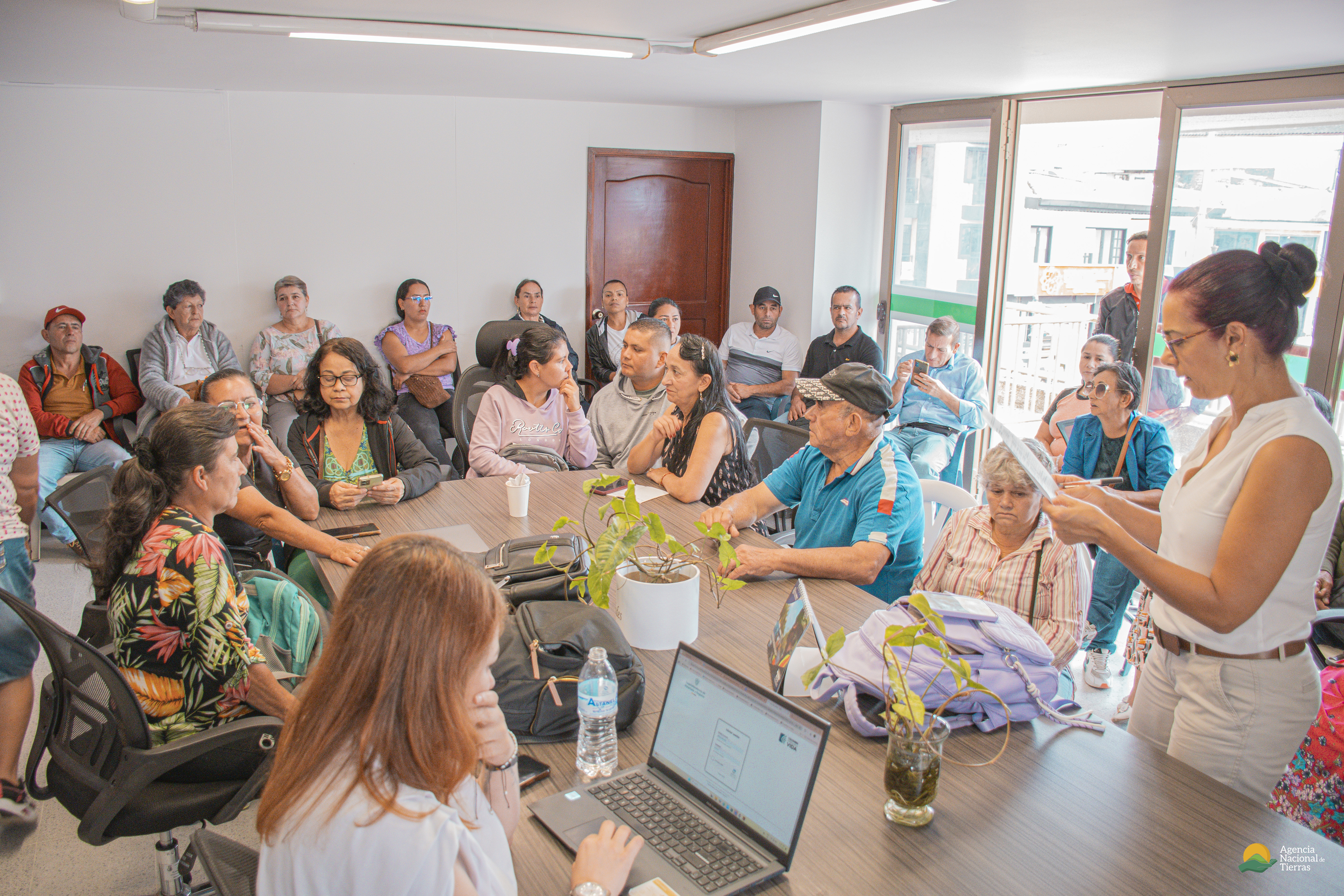 un-grupo-de-personas-sentadas-alrededor-de-una-mesa-con-computadoras