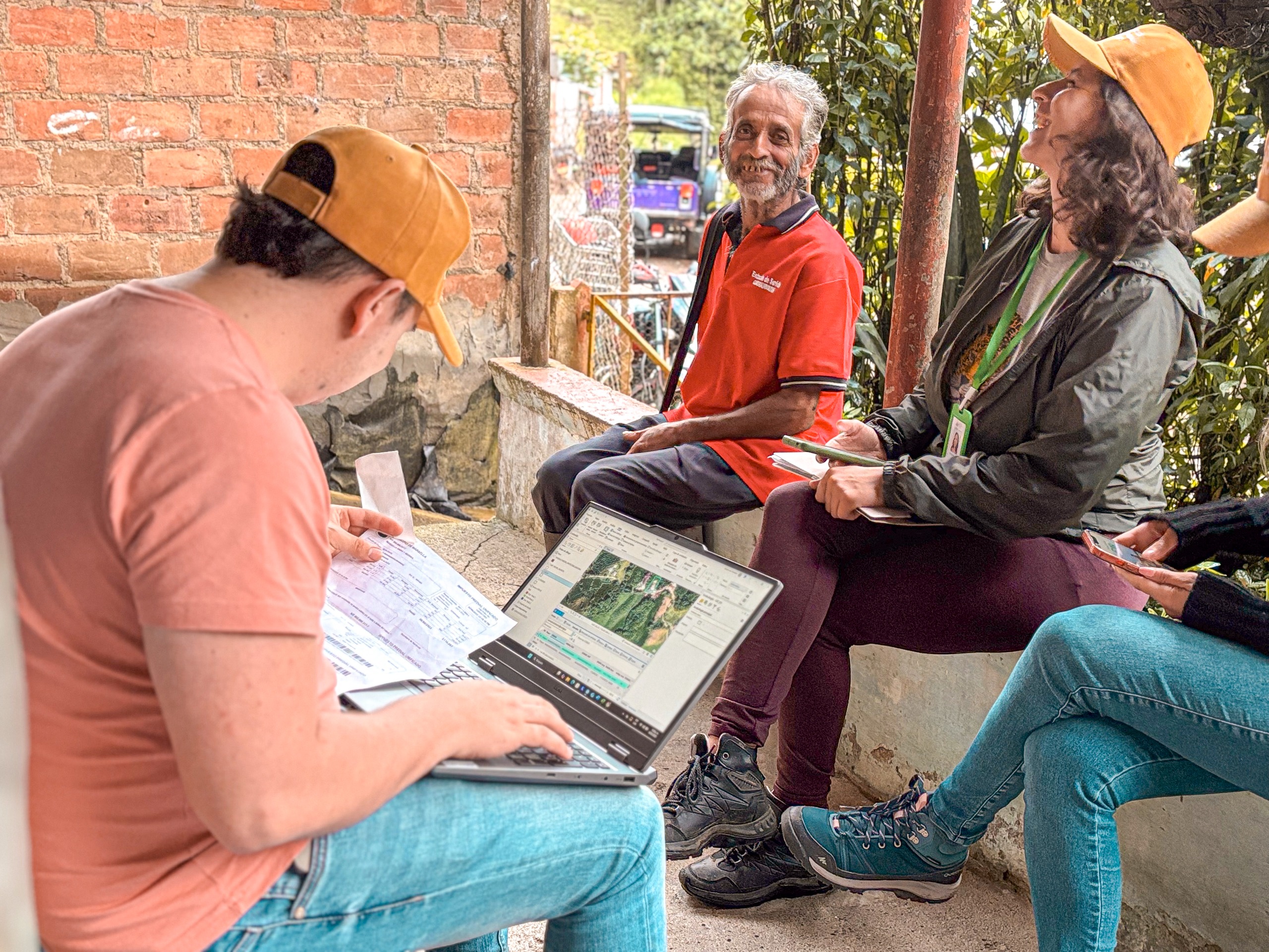 un-grupo-de-personas-sentadas-en-un-banco-con-computadoras-porttiles