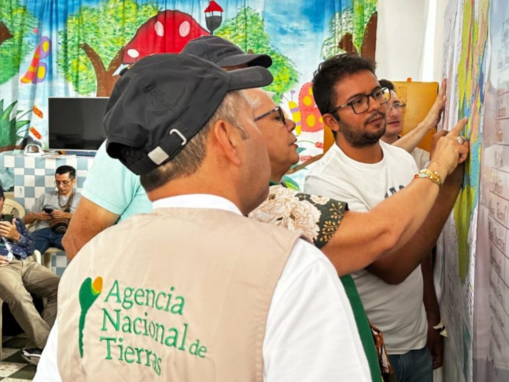 Funcionarios de la Agencia Nacional de Tierras y funcionarios de alcaldías municipales de Paicol y El Agrado en el Huila revisando el mapa.