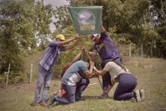 Campesinos sembrando simbolicamente una bandera de una asociación.