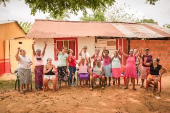 Grupo de 12 mujeres beneficiadas con la entrega de tierras.